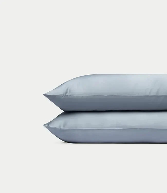 Two Cozy Earth Bamboo Pillowcases in Harbor Mist stacked on top of each other against a plain, light gray background.