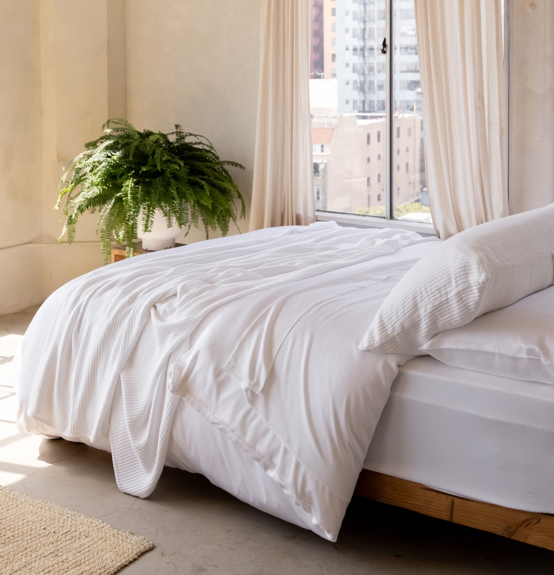 Bed with white bedding in a sunny room