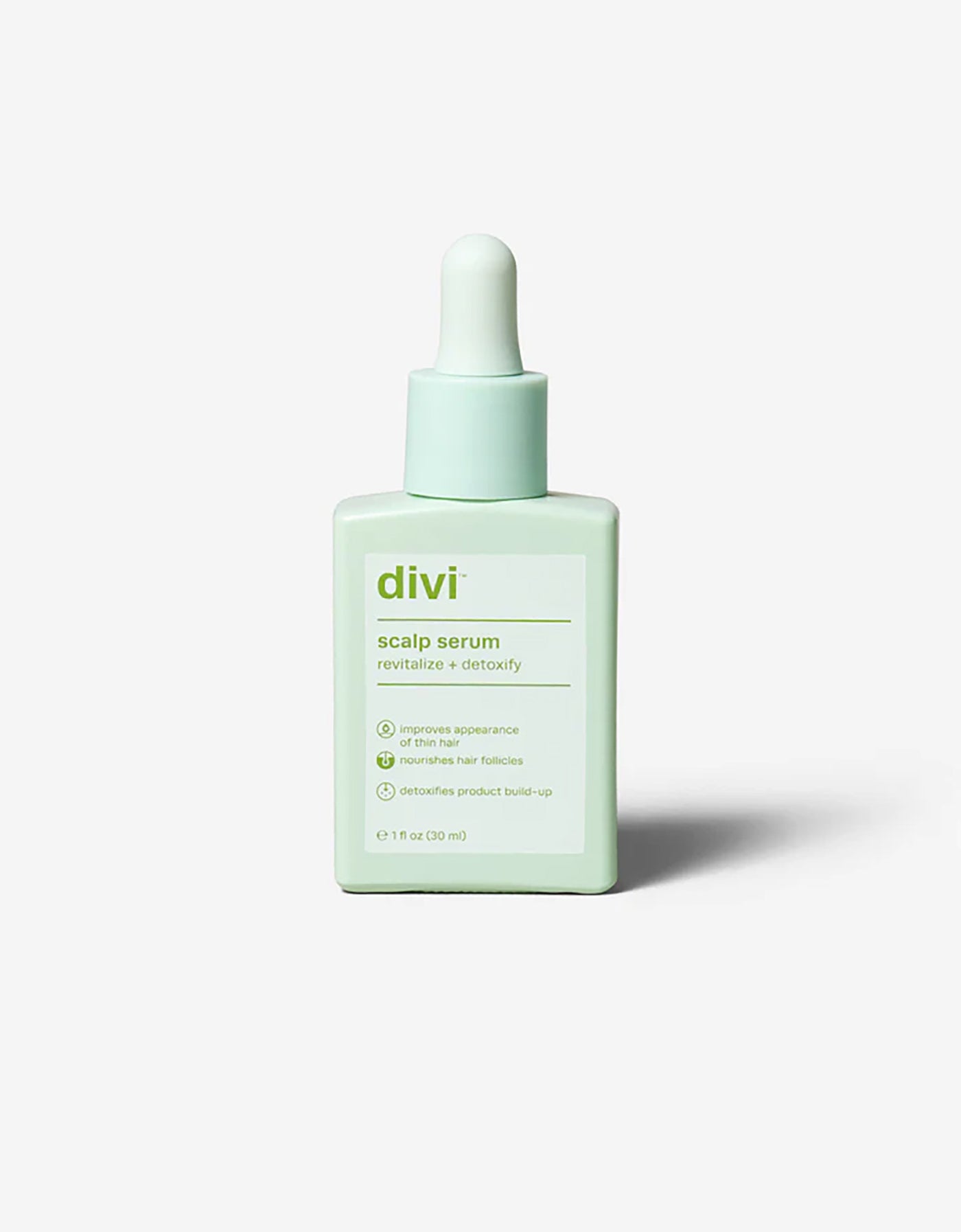 A mint green dropper bottle labeled "Cozy Earth x Divi: The Limited-Edition Dream Set" features benefits like improving appearance, nourishing hair follicles, and detoxifying build-up, set against a plain white background. Brand: Cozy Earth.