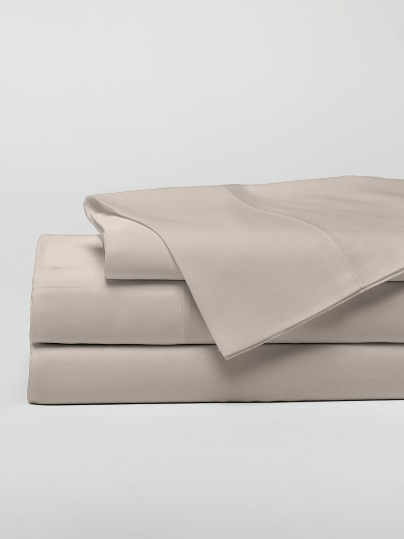 A neatly folded stack of Cozy Earth's Bamboo Sheet Set in Driftwood displayed against a plain white background. The set includes a flat sheet, a fitted sheet, and pillowcases, all meticulously arranged with a smooth and clean appearance.