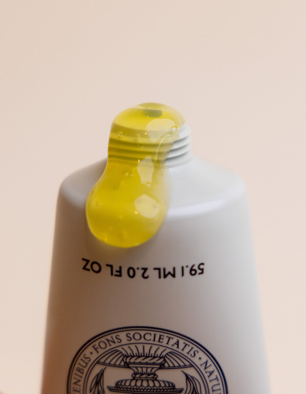 A close-up of the Cozy Earth Enzyme Mask shows yellow gel oozing from an open, upside-down white tube with black text and part of a round seal visible on its surface.