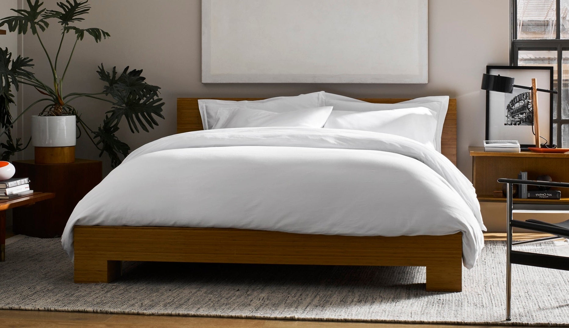 Wooden bed with white bedding in a bedroom setting