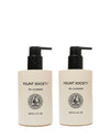 Two beige pump bottles from Cozy Earth’s Double Cleanse Duo—Oil Cleanser on the left, Gel Cleanser on the right—feature black pumps, black text, round front emblems, and each holds 148 mL (5 fl oz).