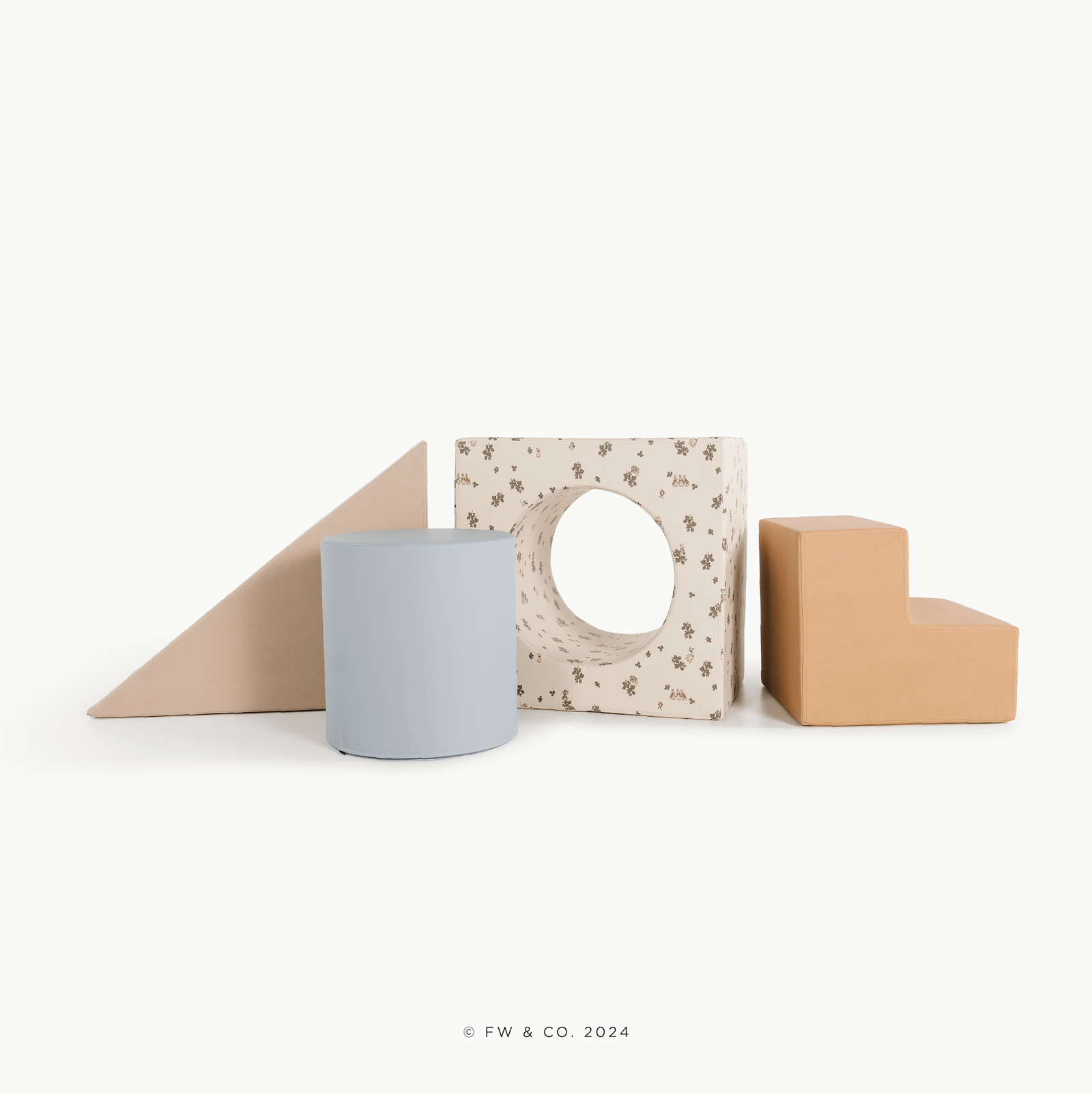 The Gathre Wholesale Block Playset features four soft blocks in Peter Rabbit™, Our Beatrix Blue, Millet, and Wheat colors, arranged in a row on a white background.