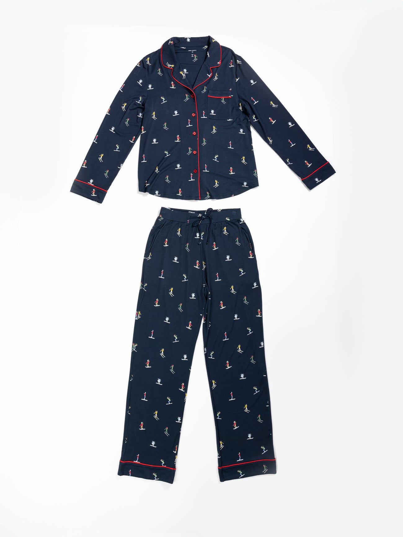 The Last Chance Women's Bamboo Stretch-Knit Pajama Set by Cozy Earth is navy blue with small multicolored ski prints, features a collared, button-down long-sleeve top with red piping, and drawstring waist pants. 