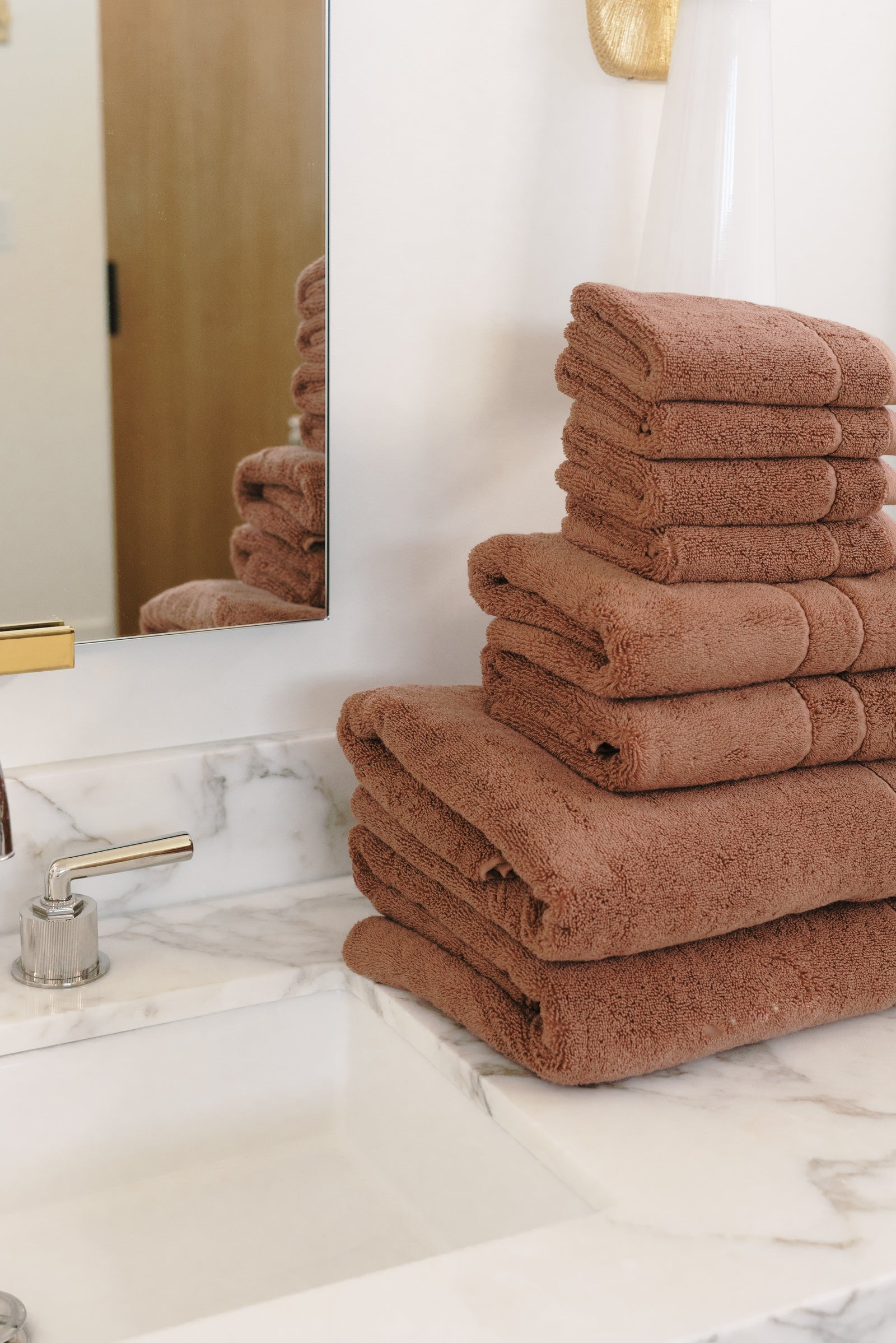 Premium Plush Bath Towel Set in the color Clay. Photo of Clay Premium Plush Bath Towel Set taken in a bathroom featuring white backsplash tile 