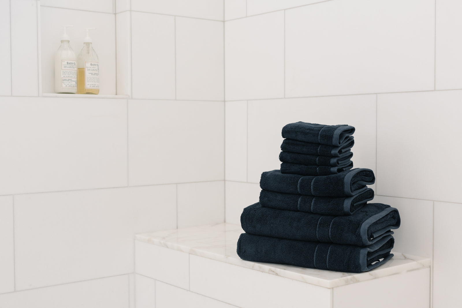 Premium Plush Bath Towel Set in the color Dusk. Photo of Dusk Premium Plush Bath Towel Set taken in a bathroom featuring white backsplash tile 