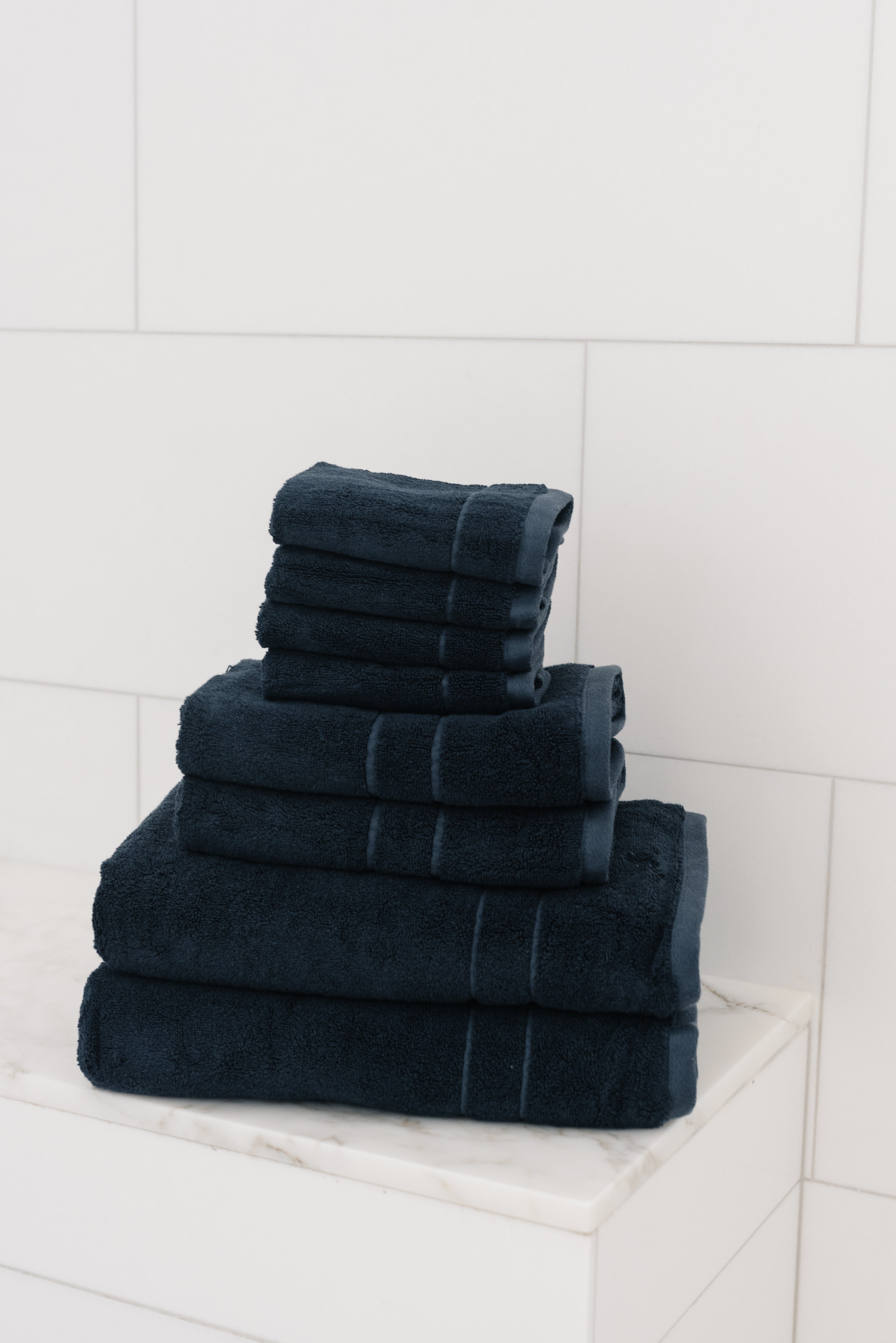 Premium Plush Bath Towel Set in the color Dusk. Photo of Dusk Premium Plush Bath Towel Set taken in a bathroom featuring white backsplash tile |Color:Dusk