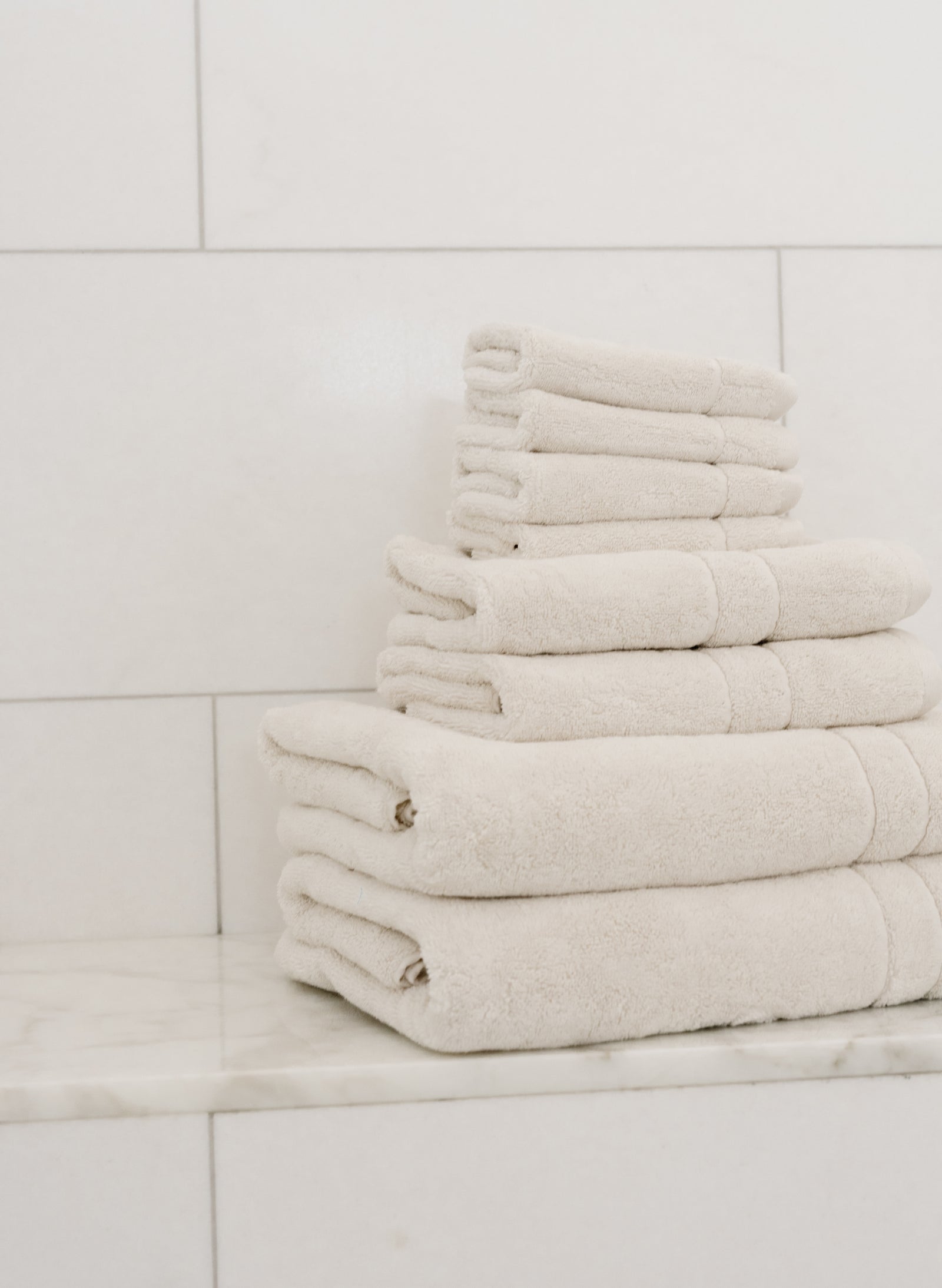 Premium Plush Bath Towel Set in the color Seashell. Photo of Seashell Premium Plush Bath Towel Set taken in a bathroom featuring white backsplash tile 