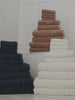 Video featuring Clay Dusk and Seashell bath sheets resting on a bathroom floor.