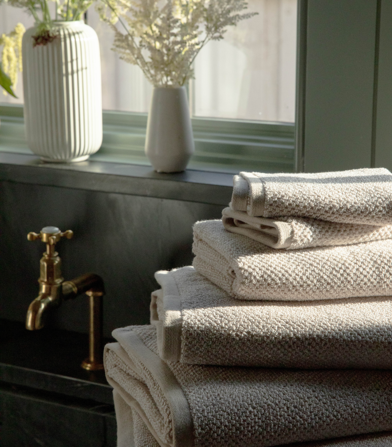 Nantucket Bath Towel bundle stacked on counter next to sink