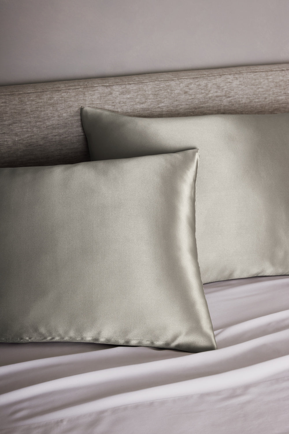 Silk Cozy Earth pillowcases on a bed with a neutral headboard