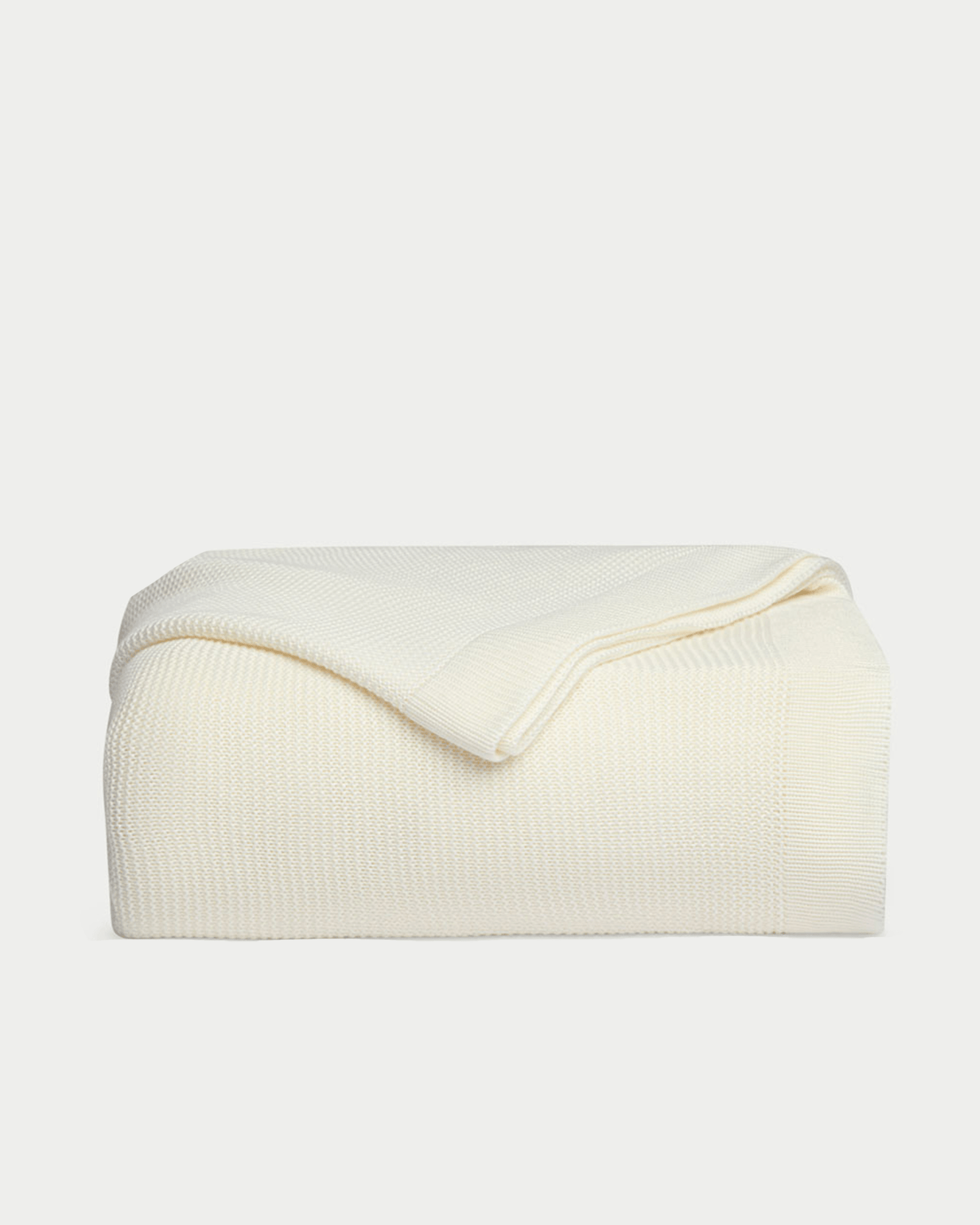 Ivory cloud knit blanket folded with white background 