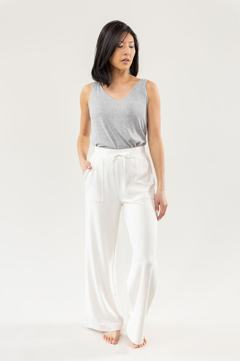 Ivory Bamboo Wide Leg Patch Pocket Pant modeled by a woman. The photo was taken in a high contrast setting, showing off the colors and lines of the pajamas.