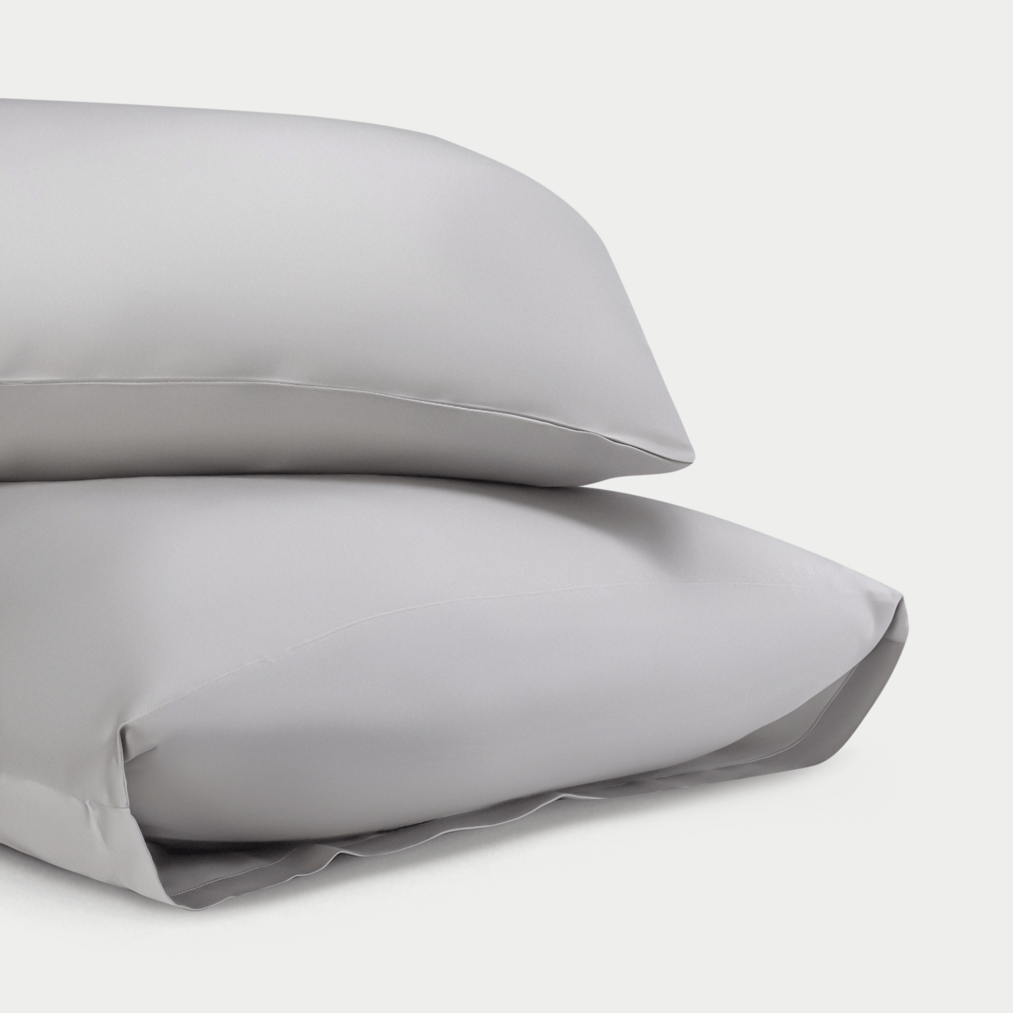 Two standard/king light grey pillowcases with plain background