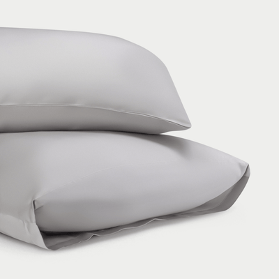 Two standard/king light grey pillowcases with plain background