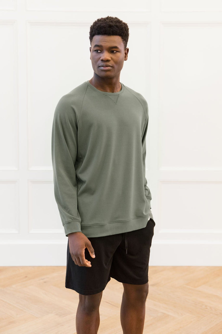 Moss | Man wearing moss-colored brushed bamboo pullover crew and black shorts