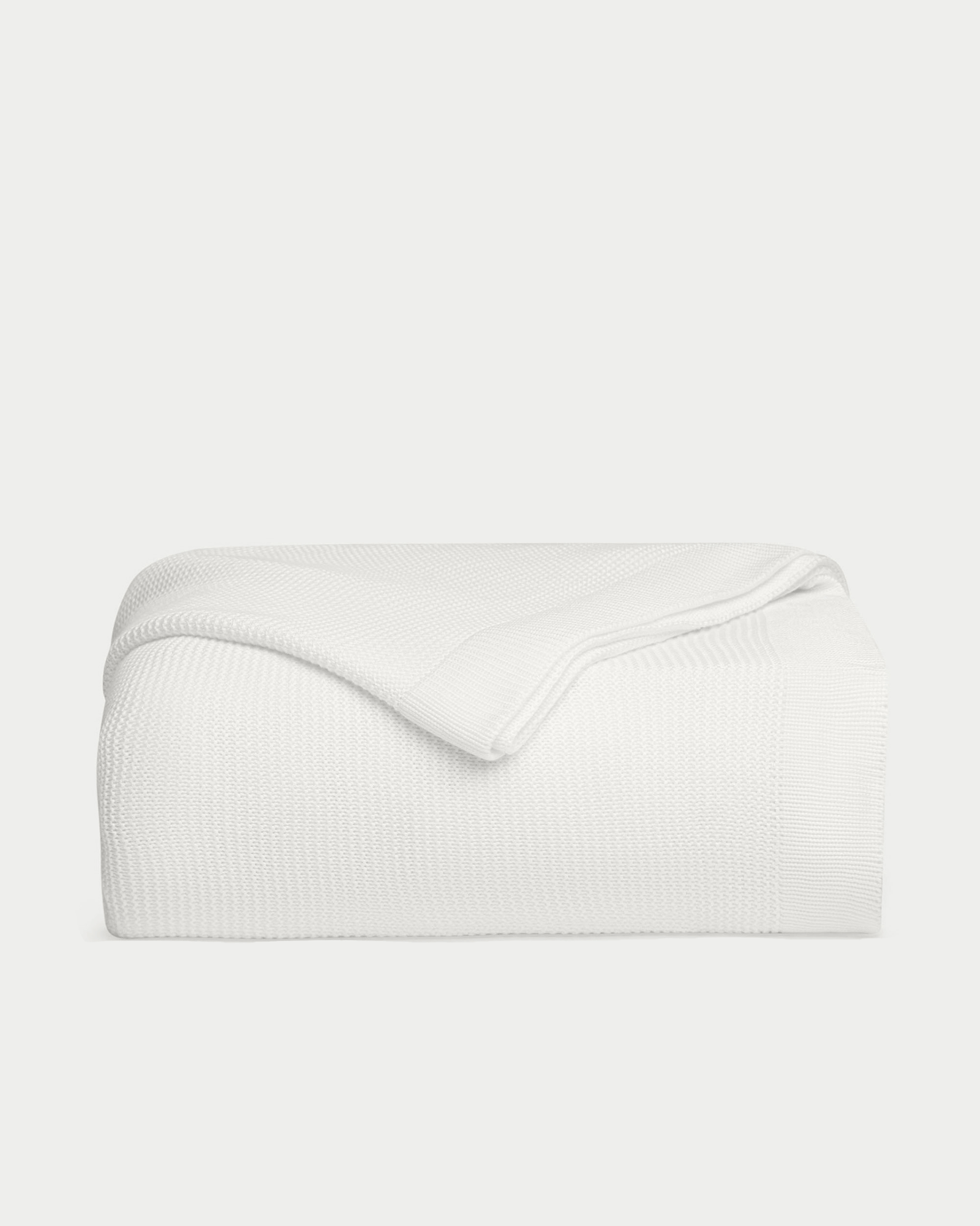 White cloud knit blanket folded with white background 