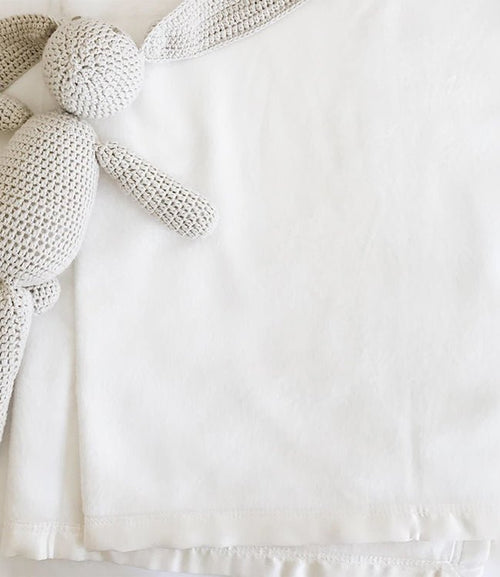 White baby blanket with knitted stuffed bunny