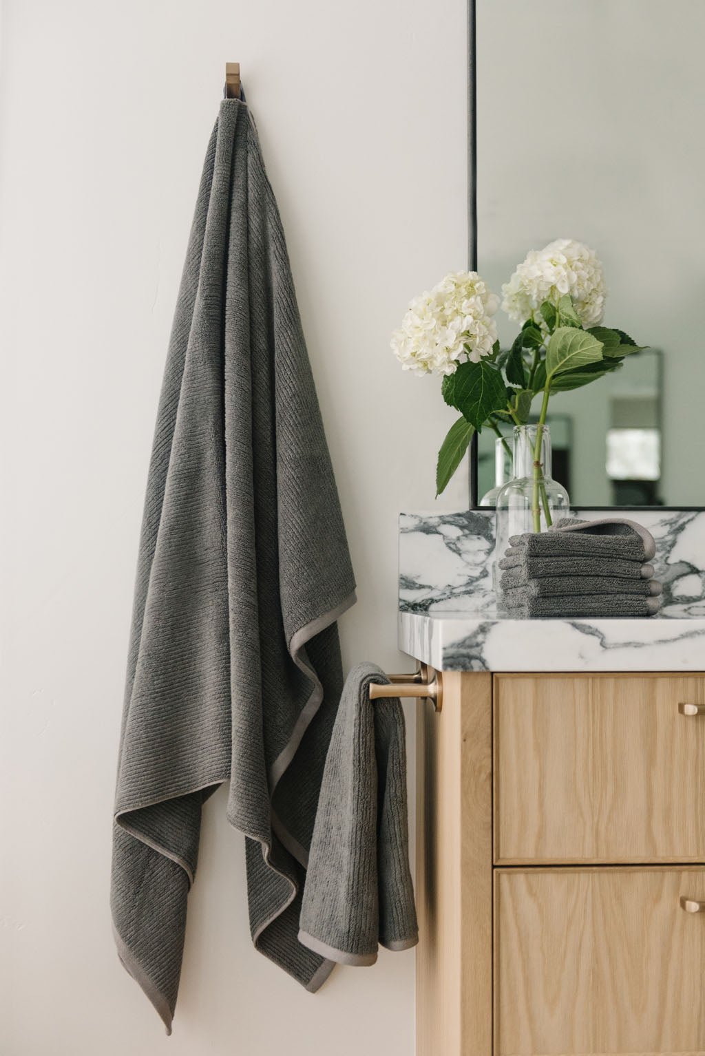 Ribbed Terry Bath Sheets in the color Charcoal. Photo of product taken in a bathroom next to a sink. |Color:Charcoal