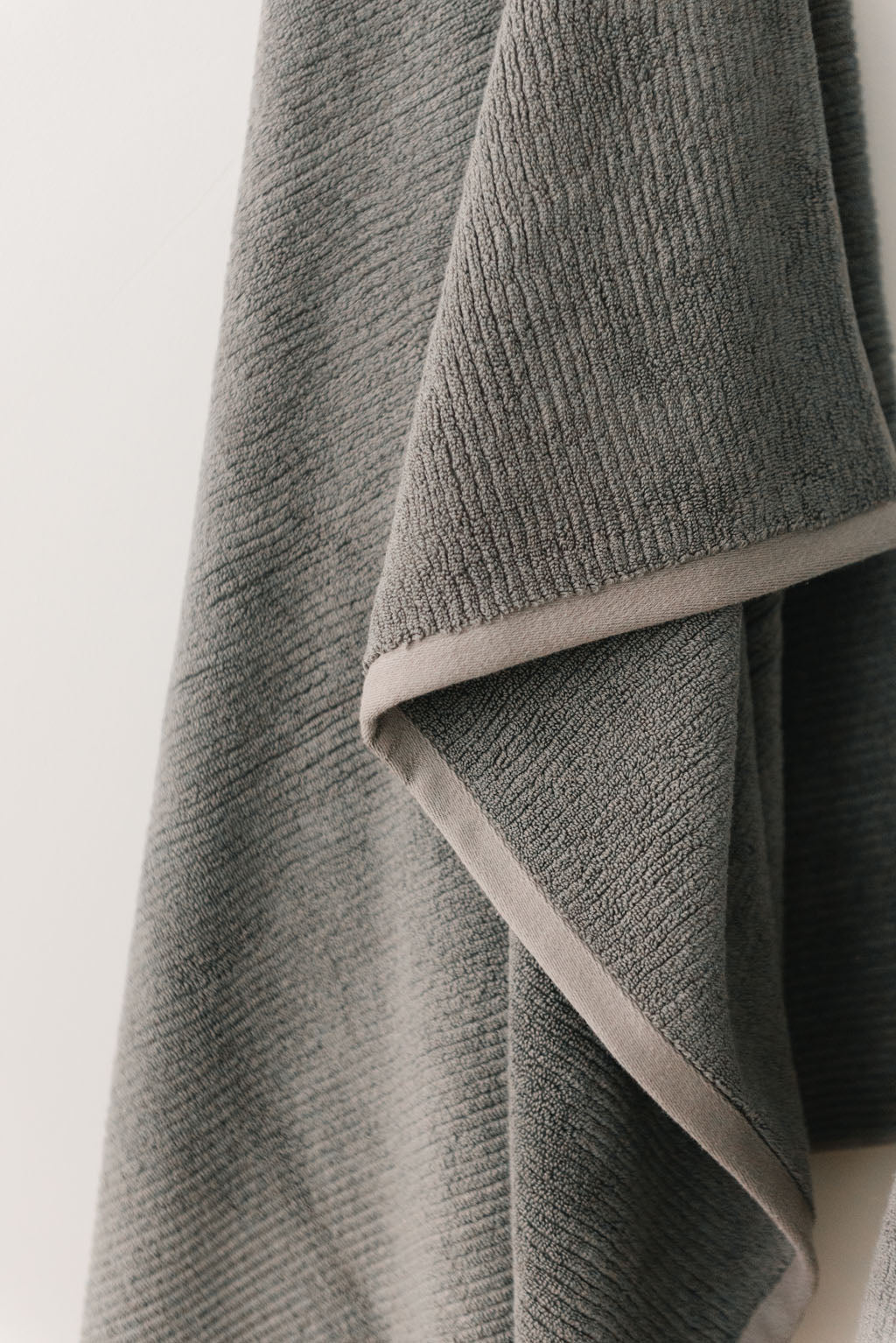 Ribbed Terry Hand Towel in the color Charcoal. Photo of Ribbed Terry Hand Towel taken with the Ribbed Terry Hand Towel resting on a bathroom sink. |Color: Charcoal