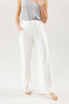 Ivory Bamboo Wide Leg Patch Pocket Pant modeled by a woman. The photo was taken in a high contrast setting, showing off the colors and lines of the pajamas. |Color: Ivory