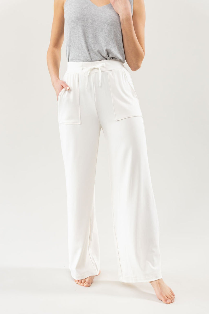 Ivory Bamboo Wide Leg Patch Pocket Pant modeled by a woman. The photo was taken in a high contrast setting, showing off the colors and lines of the pajamas.