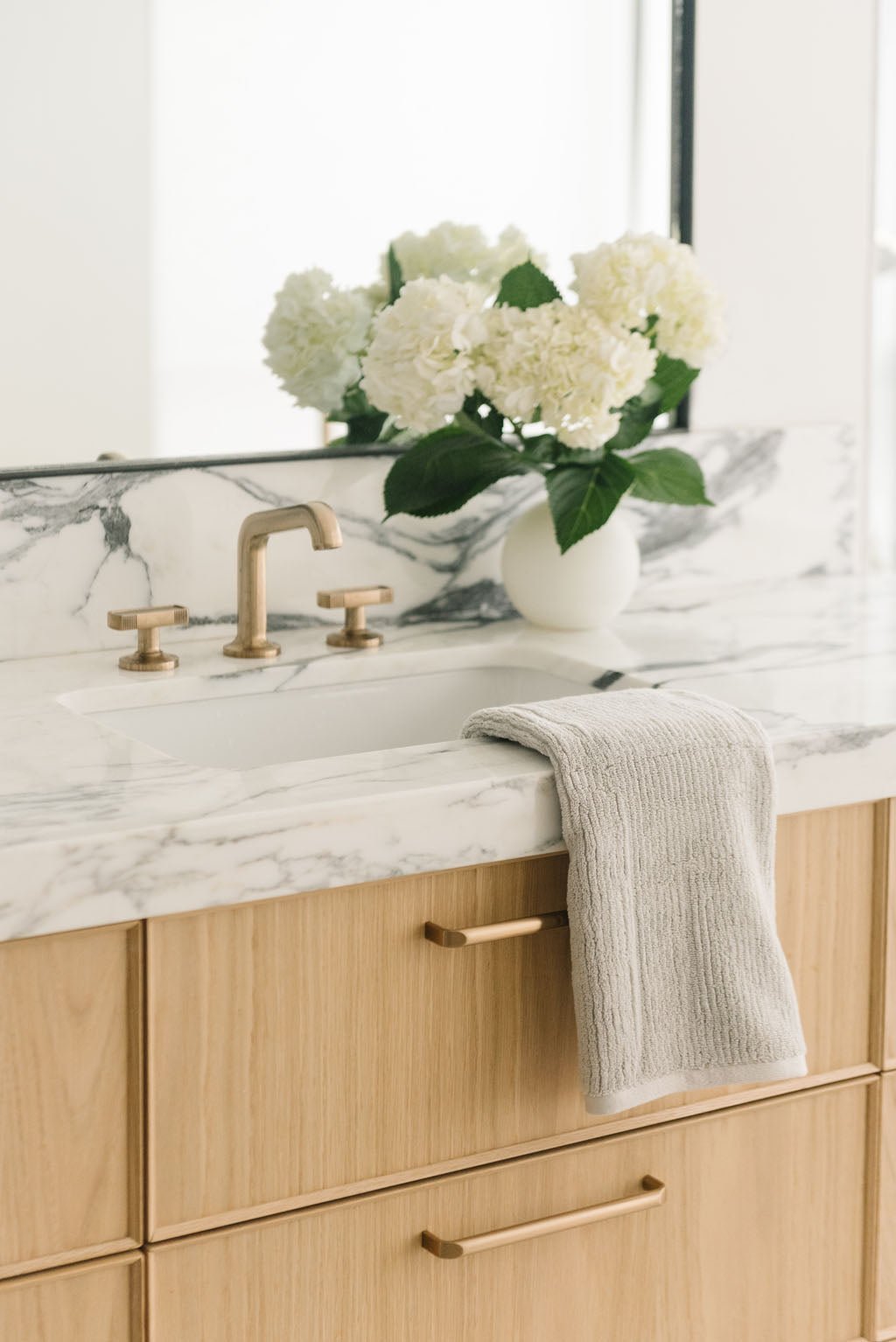 Ribbed Terry Hand Towel in the color Light Grey. Photo of Ribbed Terry Hand Towel taken with the Ribbed Terry Hand Towel resting on a bathroom sink. 