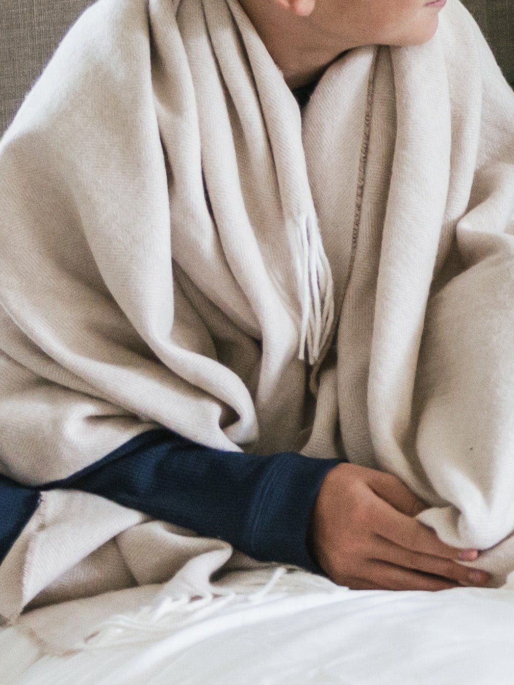 Person sitting with oatmeal throw wrapped around them |Color:Oatmeal