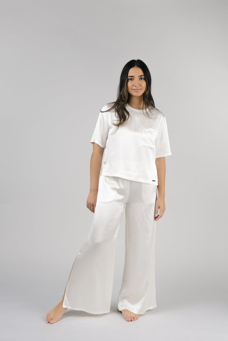 Ivory Serenity Silk Scoop Neck Tee modeled by a woman. The photo was taken in a high contrast setting, showing off the colors and lines of the tee.