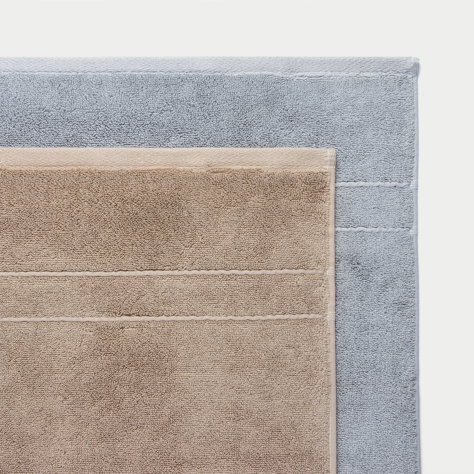 Premium Plush bath Towels in the color Sand, Harbor Mist. Photo of Sand, Harbor Mist Premium Plush bath Towels taken of the top corners of the towels with a crisp background.