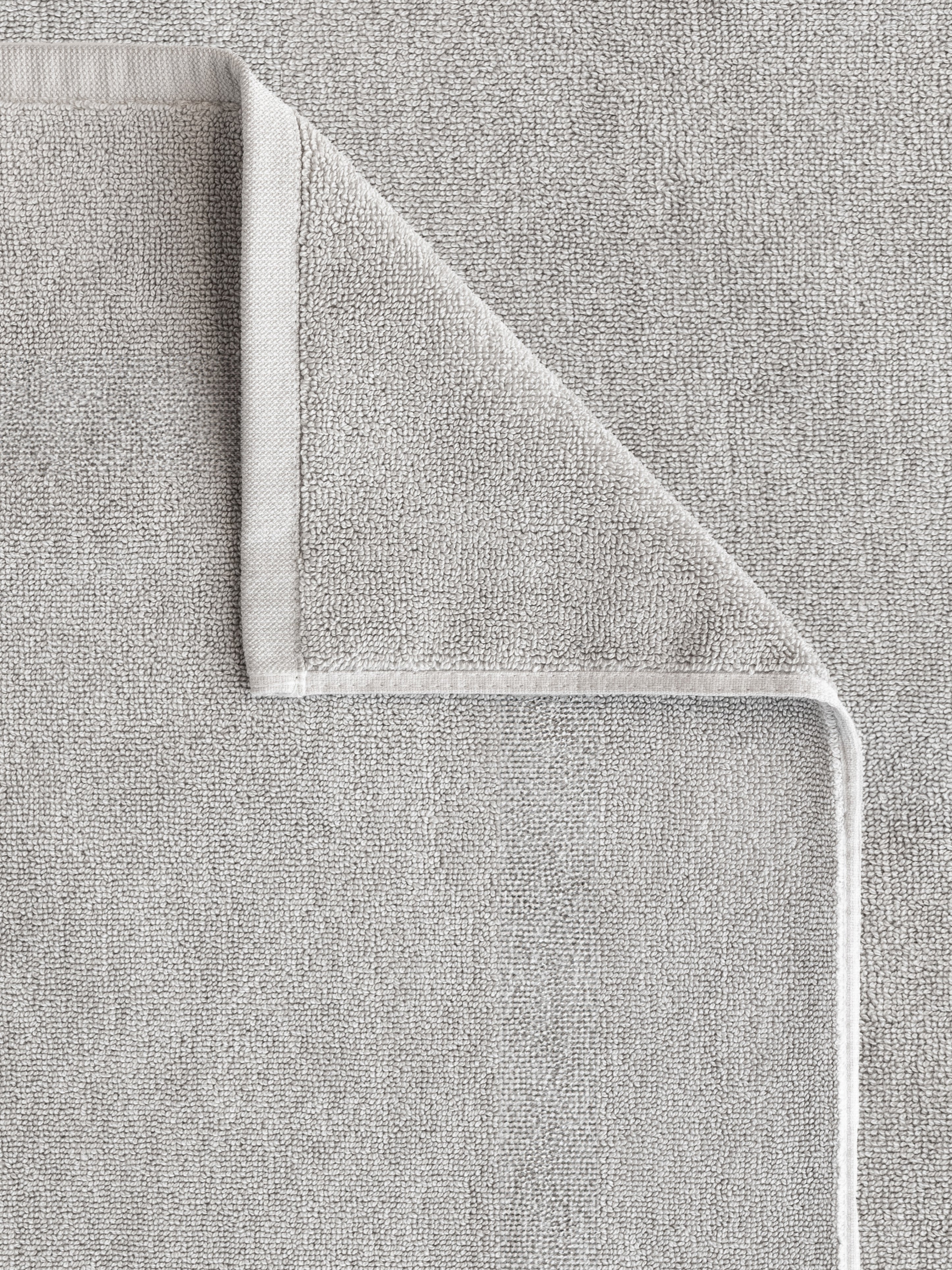 Close up shot of the Light Grey Looped Terry Bath Mat. This shot shows only the mat so that the texture of the bath mat can be seen with more clarity.