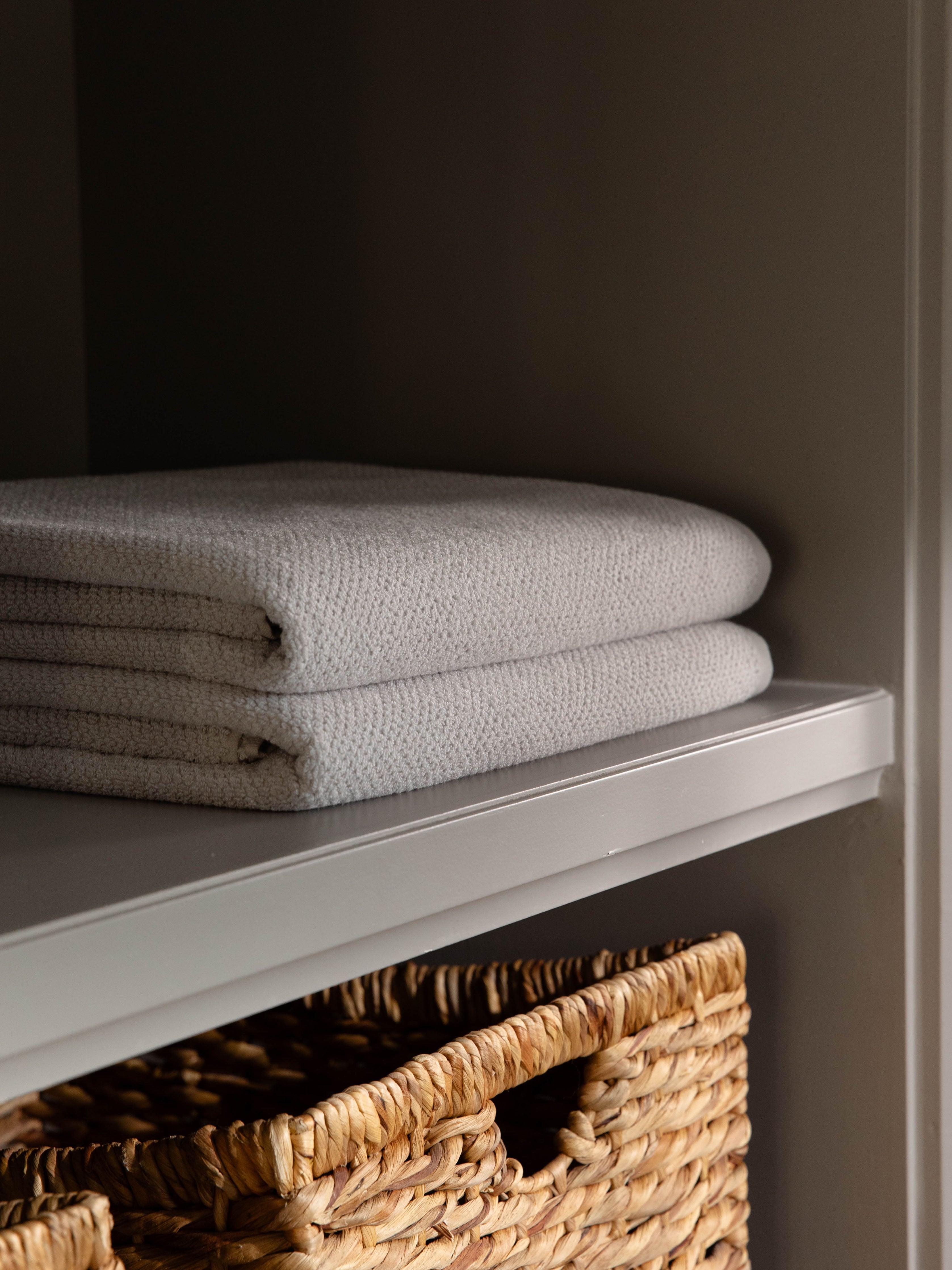 Nantucket Bath Towels in the color Heathered Light Grey. Photo of Nantucket Bath Towels taken as the towels rest on a shelf in a bathroom. |Color: Heathered Light Grey