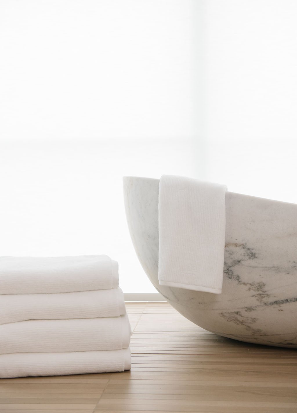White Ribbed Terry Hand Towels in the color white next to a white marble bath tub.