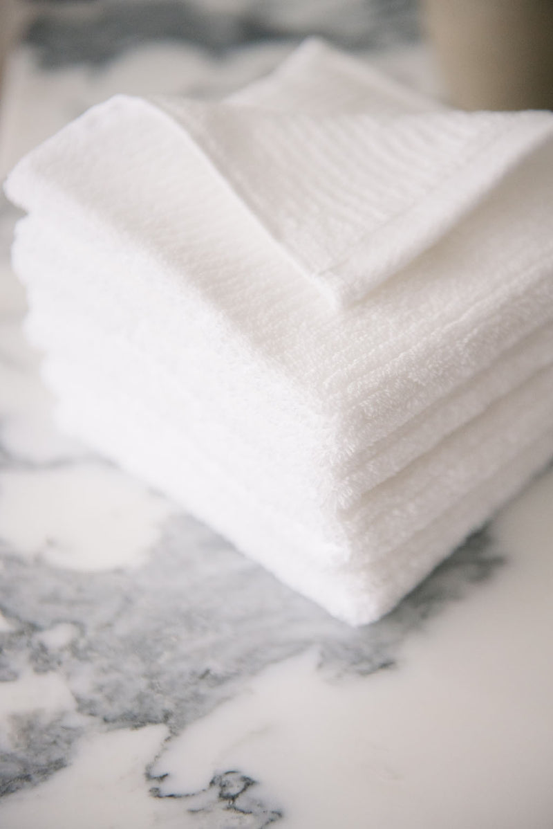 Ribbed Terry Wash Cloths in the color White. Photo of product taken on white marble sink.