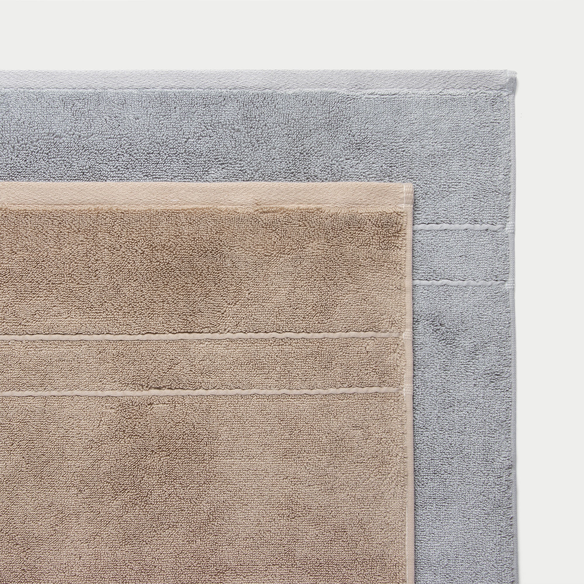 Premium Plush bath Towels in the color Sand, Harbor Mist. Photo of Sand, Harbor Mist Premium Plush bath Towels taken of the top corners of the towels with a crisp background.