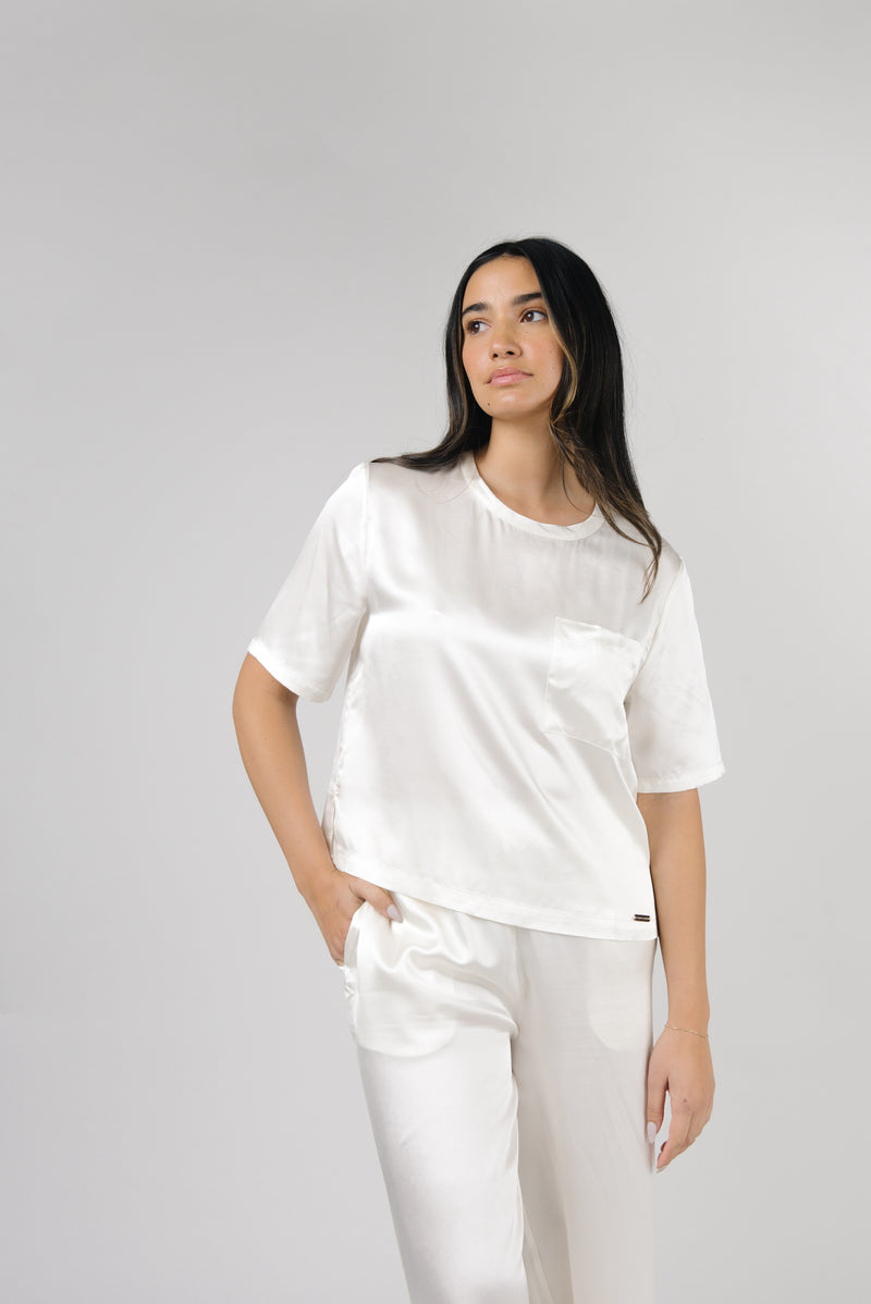 Ivory Serenity Silk Scoop Neck Tee modeled by a woman. The photo was taken in a high contrast setting, showing off the colors and lines of the tee.