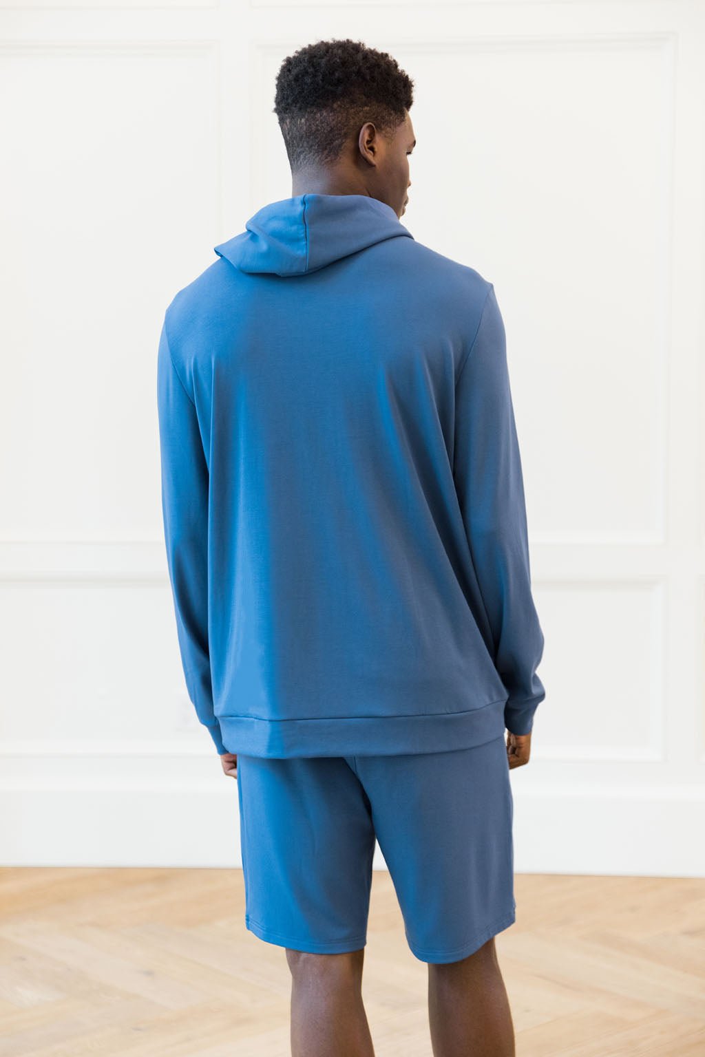 Cobalt Bamboo Hoodie worn by a man with his back facing the camera. The man is standing in front of white background.