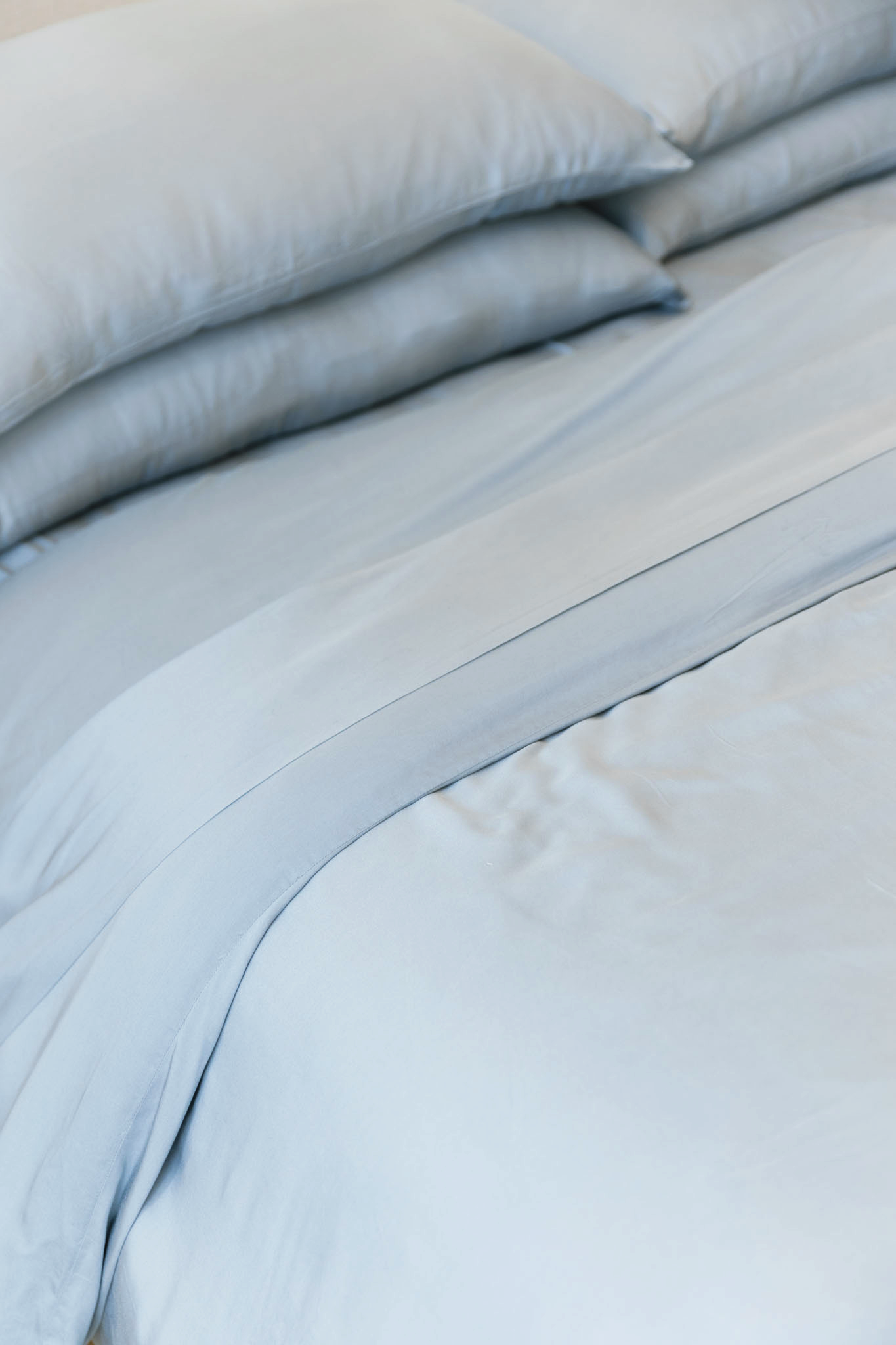 Close up of harbor mist bedding on made bed 