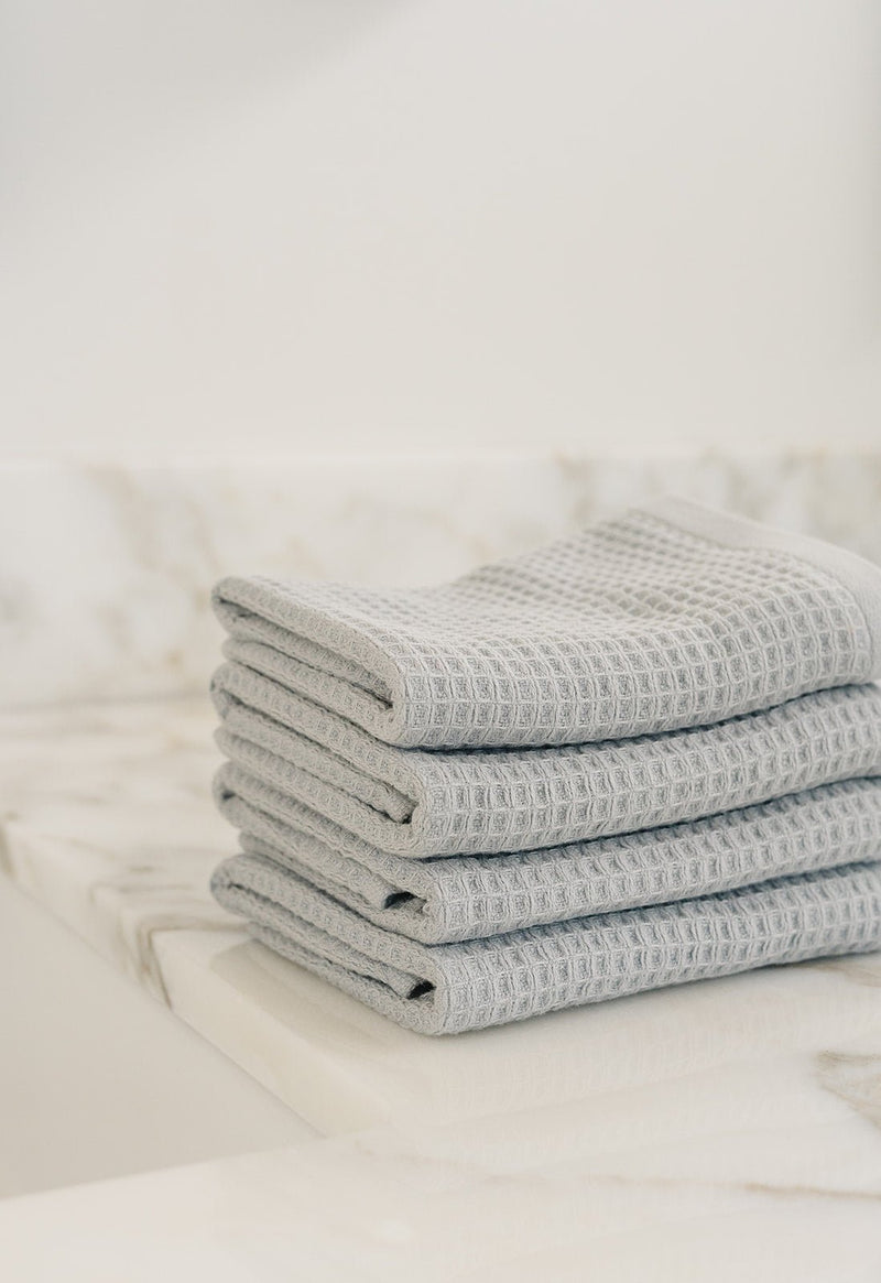 Harbor Mist Waffle Wash Cloths neatly folded. The photo was taken with the cloths resting on a white marble sink.
