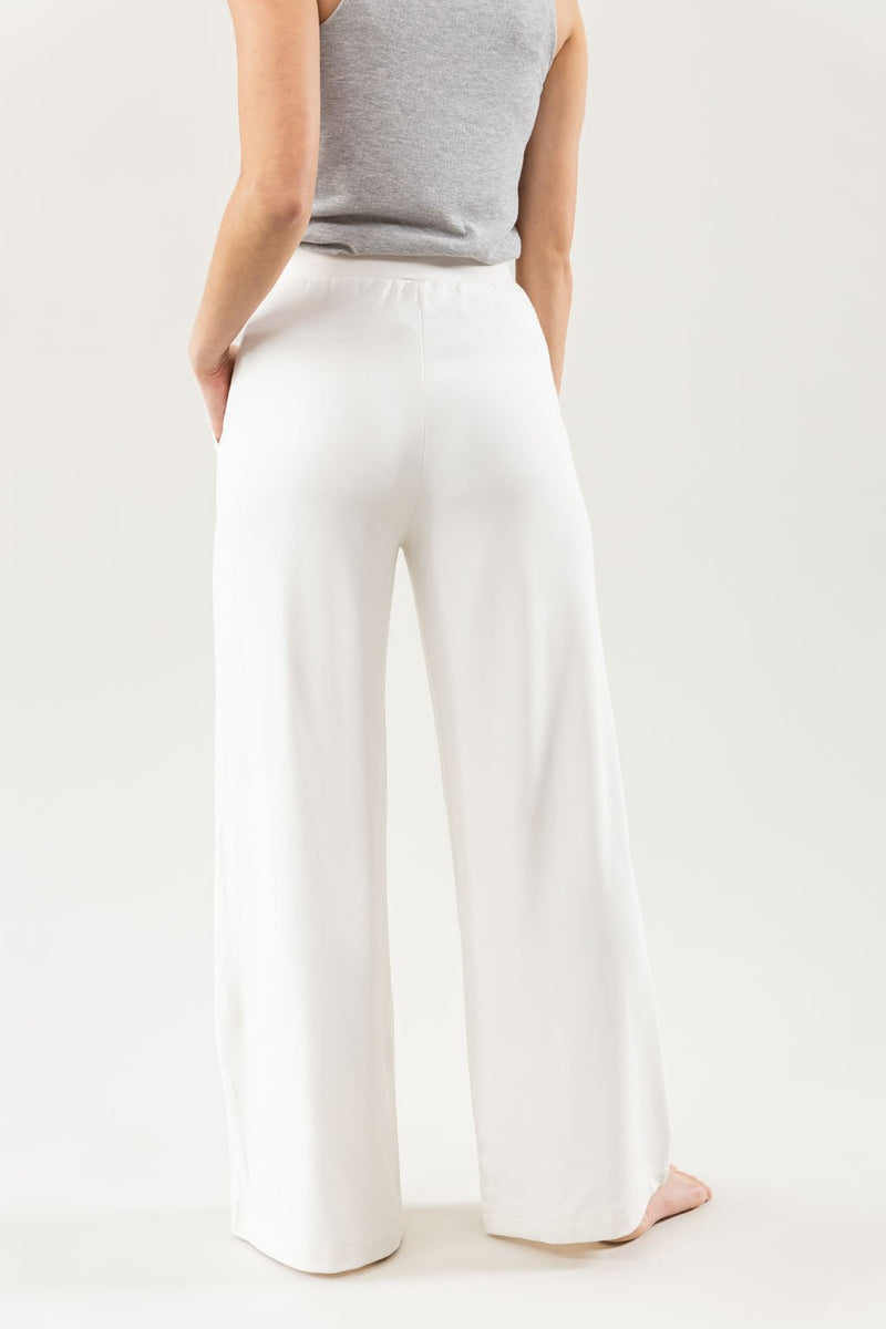 Ivory Bamboo Wide Leg Patch Pocket Pant modeled by a woman. The photo was taken in a high contrast setting, showing off the colors and lines of the pajamas.