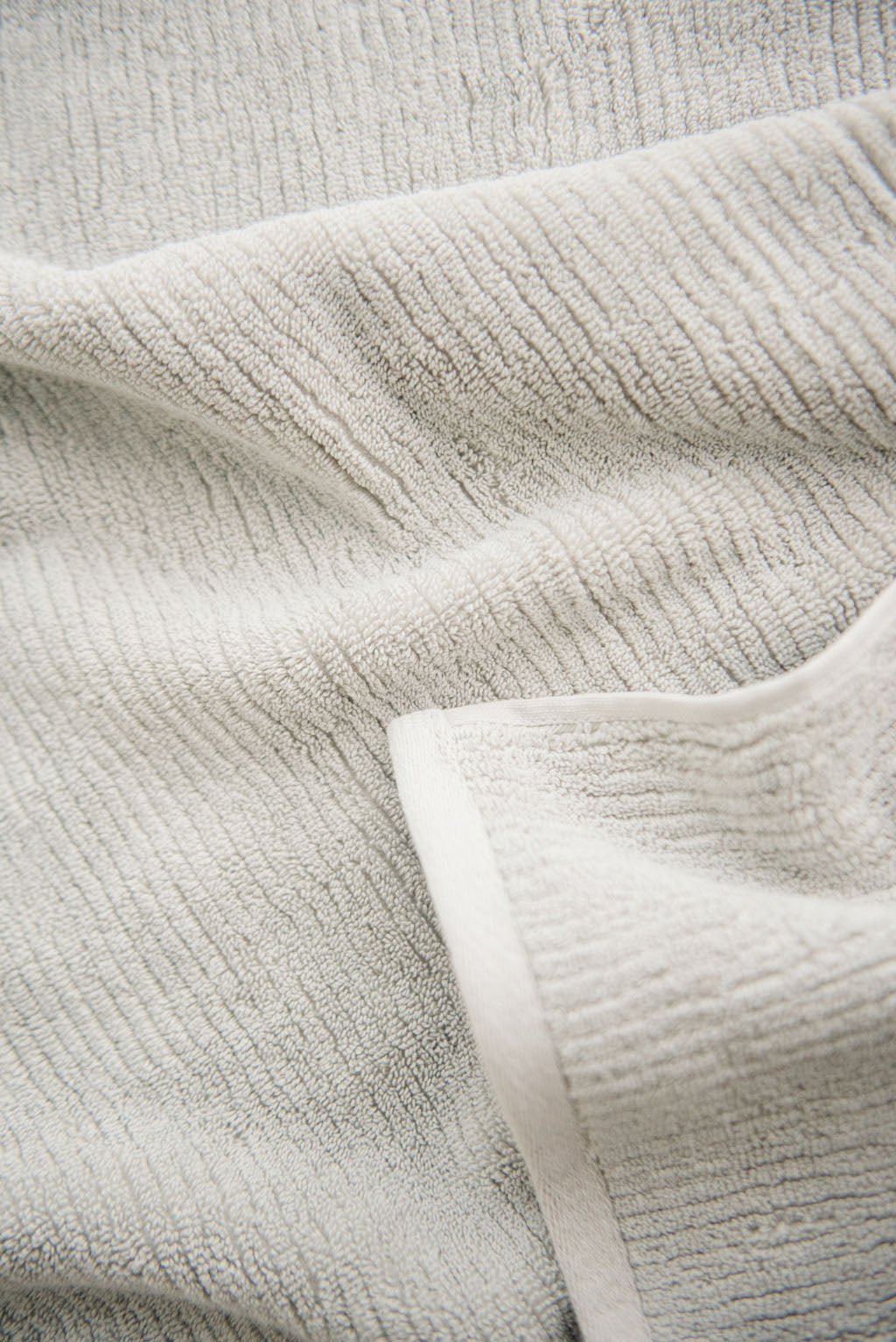 Ribbed Terry Hand Towel in the color Light Grey. Photo of Ribbed Terry Hand Towel taken as a close up of the towel. Only the towel is seen. |Color:Light Grey