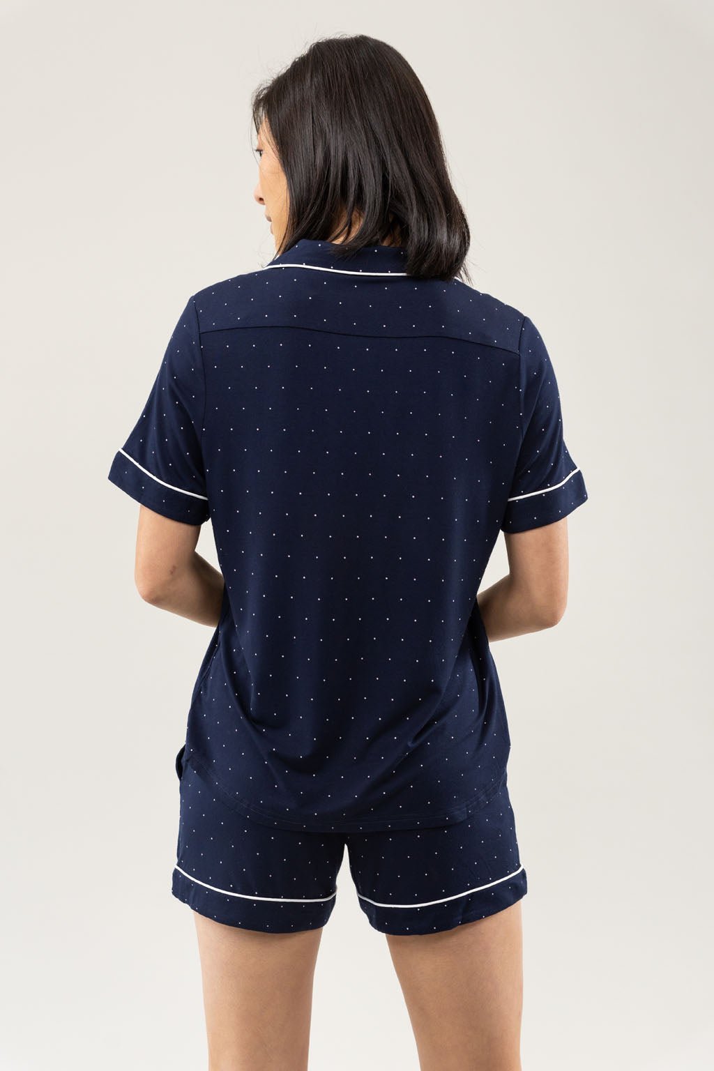 Mini Dot Short Sleeve Pajama Set modeled by a women. The photo was taken in a light setting; showing off the pajamas. 