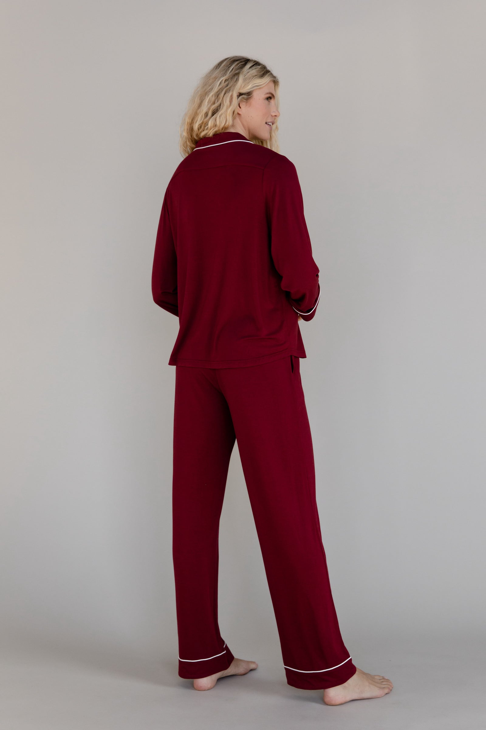 Pomegranate Long Sleeve Pajama Set modeled by a woman. The photo was taken in a high contrast setting, showing off the colors and lines of the pajamas. 