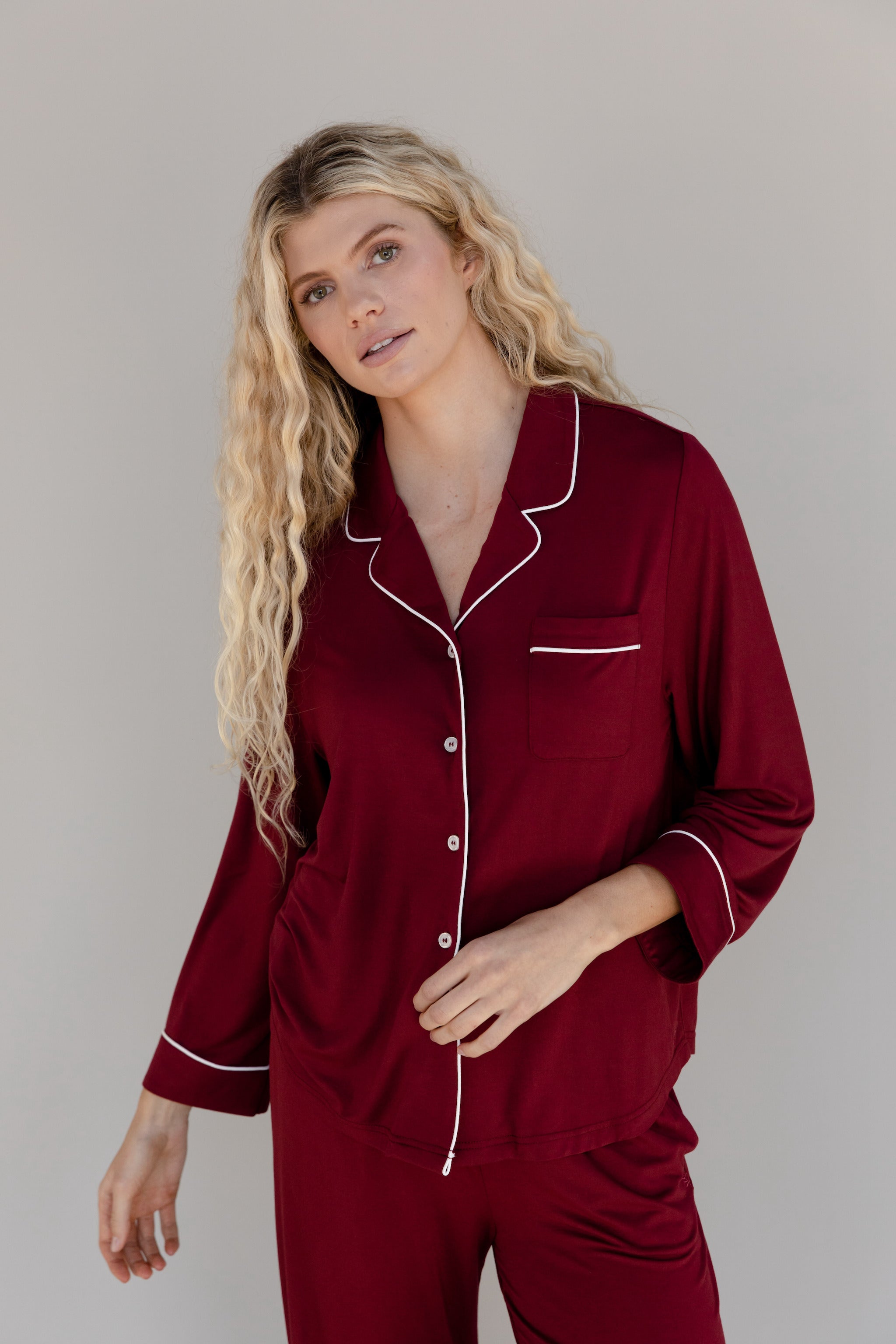 Pomegranate Long Sleeve Pajama Set modeled by a woman. The photo was taken in a high contrast setting, showing off the colors and lines of the pajamas. |Color:Pomegranate
