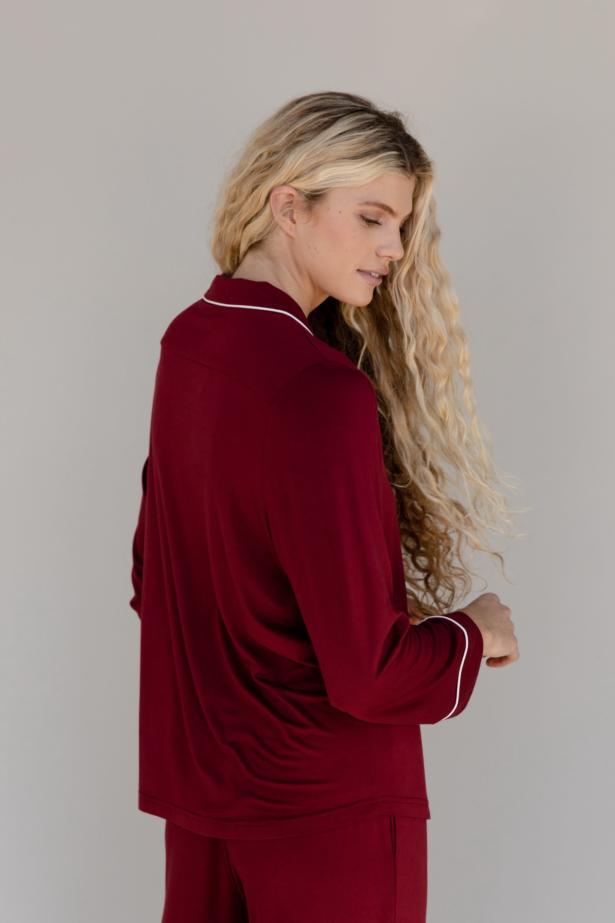 Pomegranate Long Sleeve Pajama Set modeled by a woman. The photo was taken in a high contrast setting, showing off the colors and lines of the pajamas. 