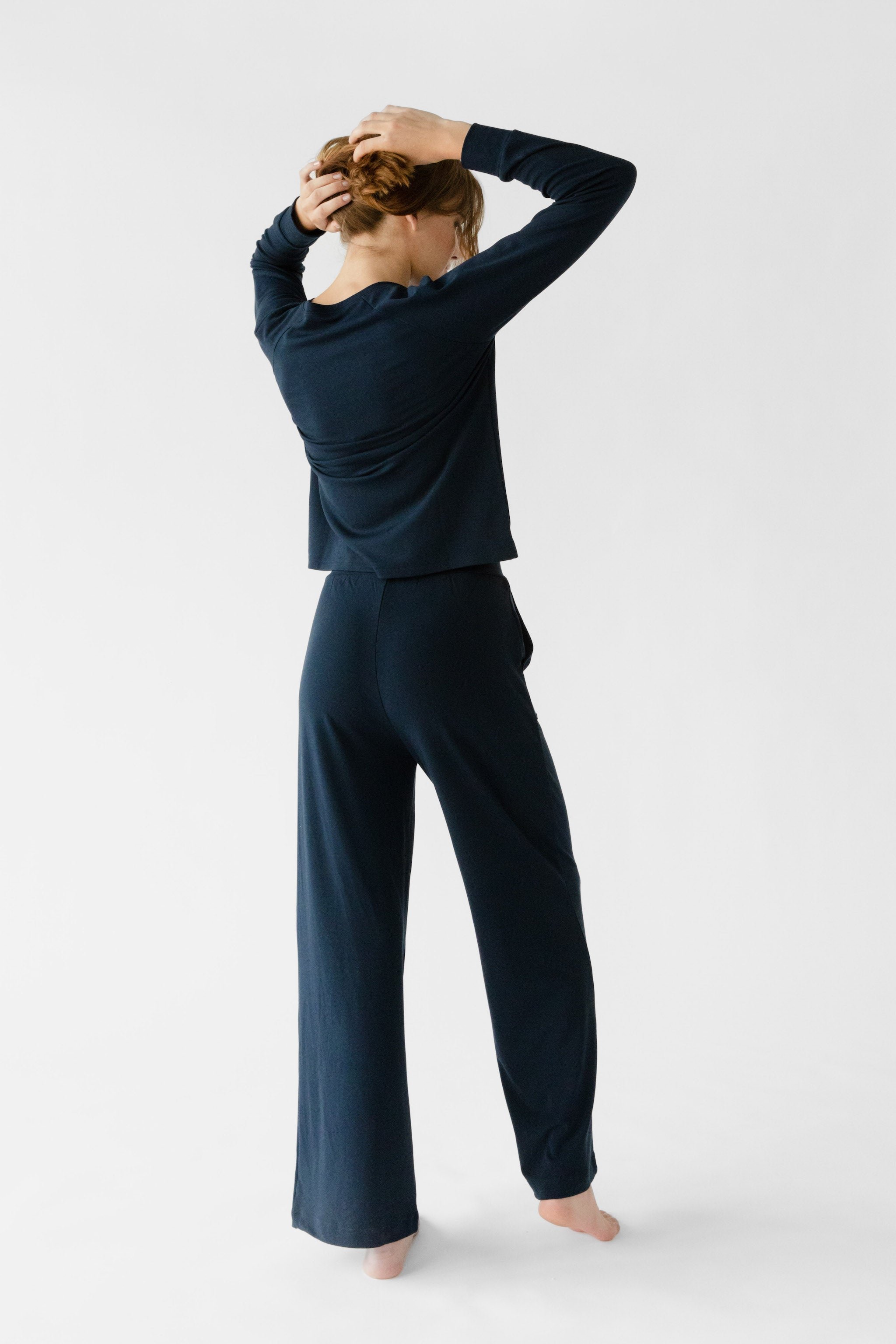 Navy Bamboo Wide Leg Patch Pocket Pant modeled by a woman. The photo was taken in a high contrast setting, showing off the colors and lines of the pajamas. |Color: Navy