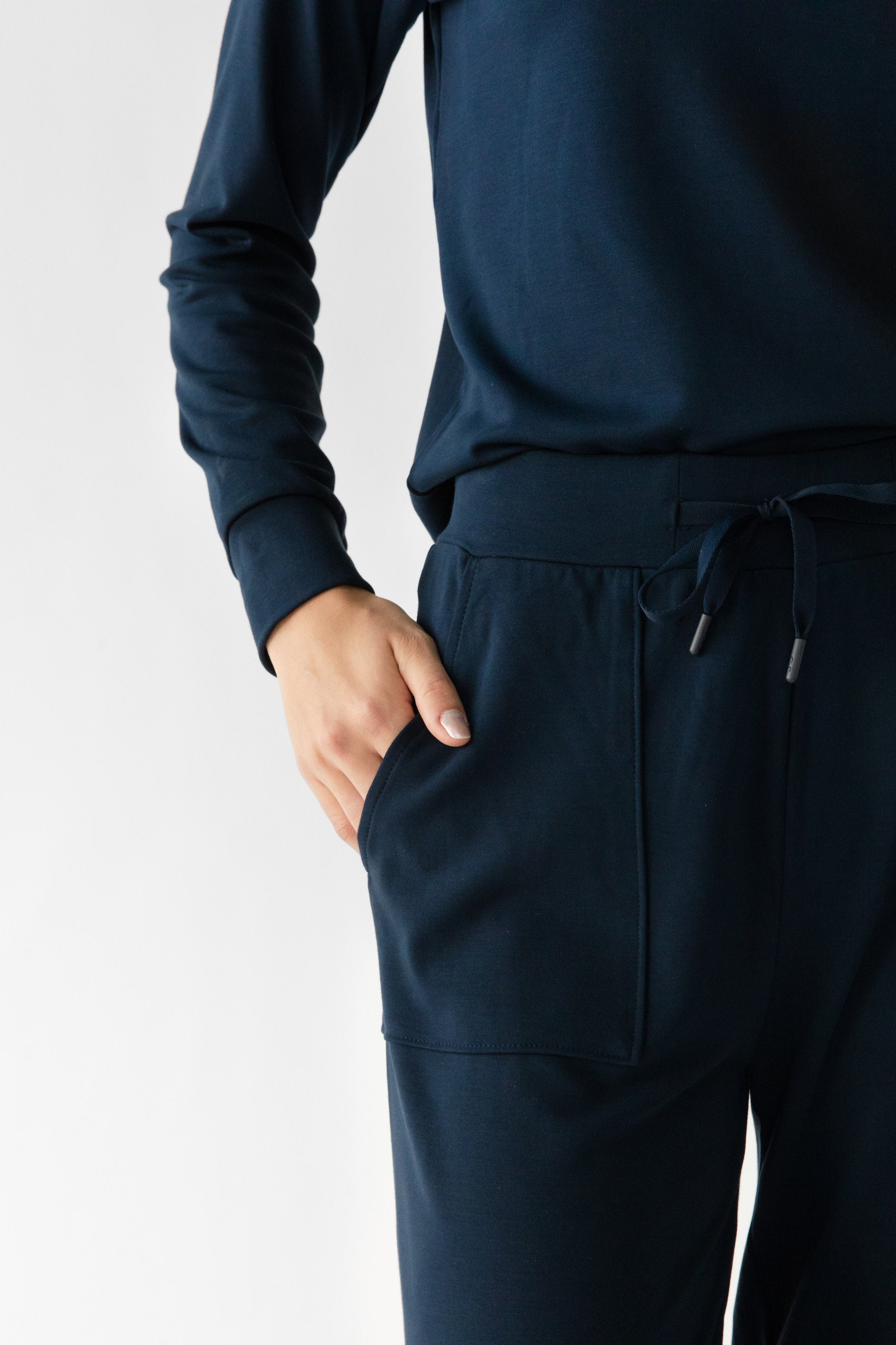 Navy Bamboo Wide Leg Patch Pocket Pant modeled by a woman. The photo was taken in a high contrast setting, showing off the colors and lines of the pajamas. |Color: Navy