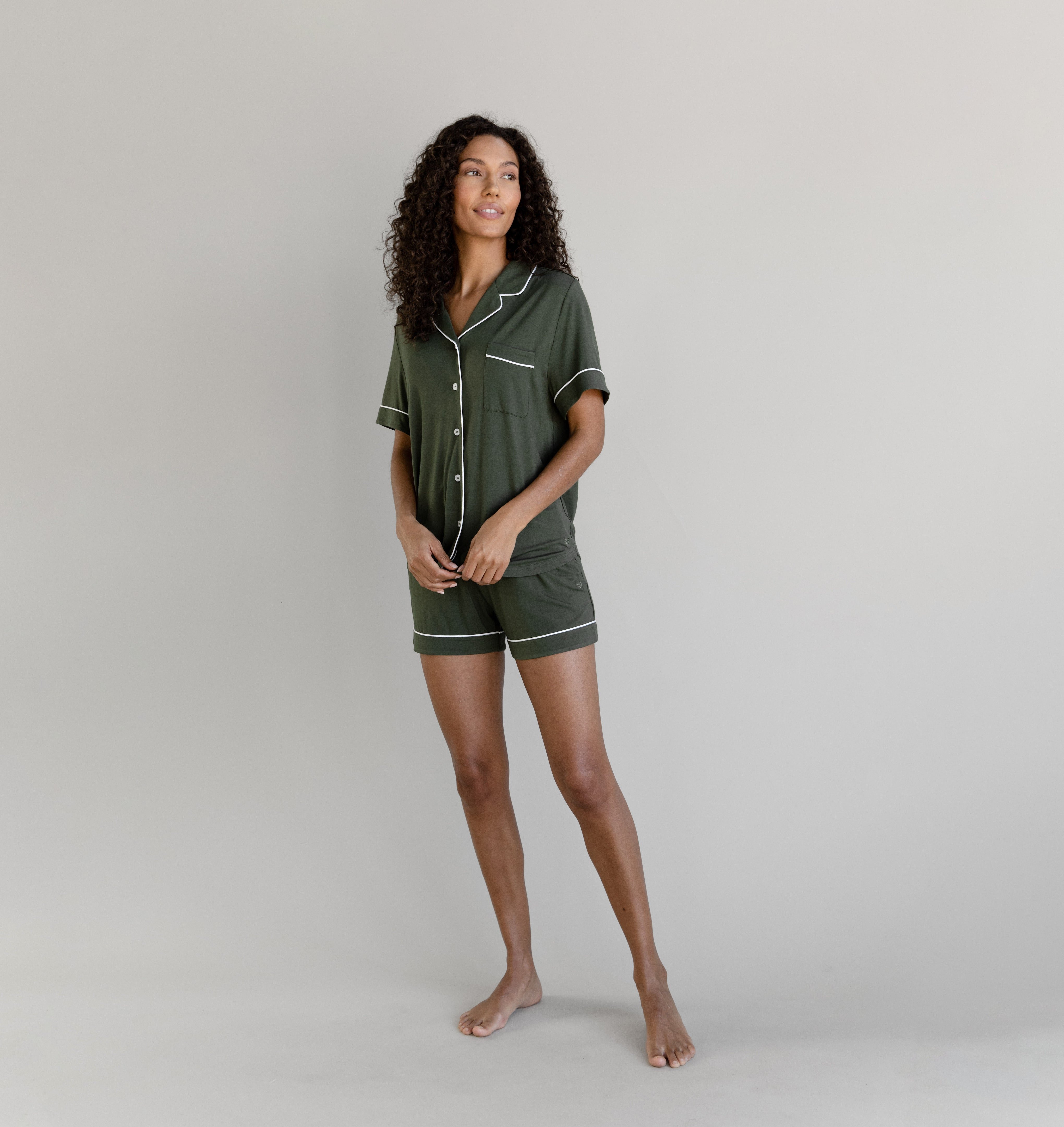 Olive Short Sleeve Pajama Set modeled by a women. The photo was taken in a light setting; showing off the pajamas. 