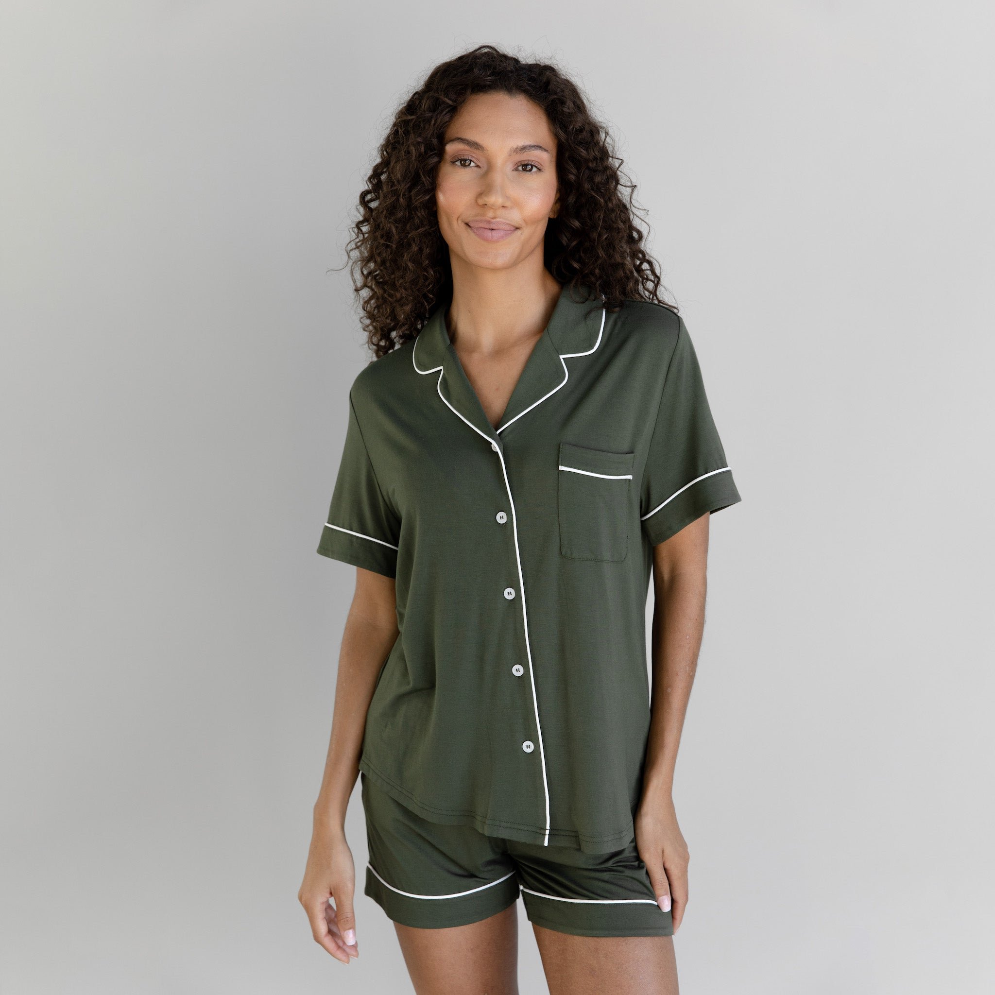 Olive Short Sleeve Pajama Set modeled by a women. The photo was taken in a light setting; showing off the pajamas. 